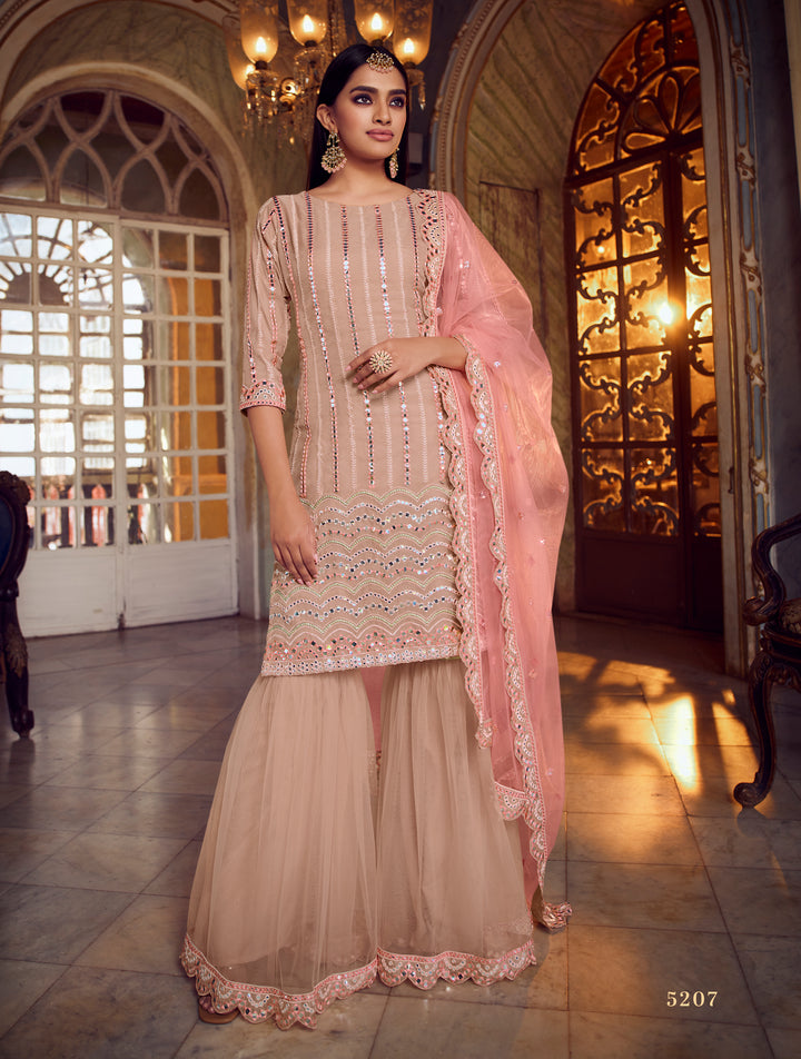 Traditional peach net suit with mirror & thread work, ideal for festive events like weddings.