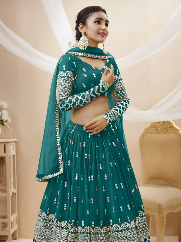 Elegant teal-blue lehenga choli in georgette fabric with intricate sequins and zari work, ideal for weddings.