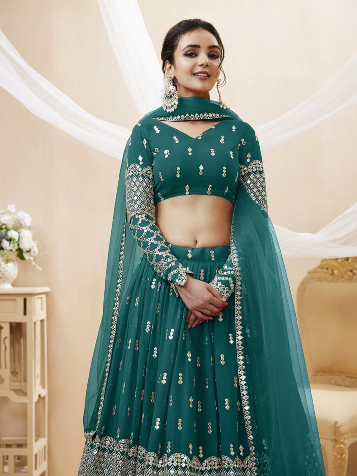 Traditional teal-blue lehenga choli with sequins and zari work, designed for luxury weddings and celebrations.