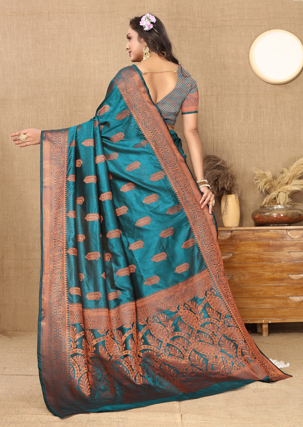 Elegant teal-blue silk saree with intricate zari border, ideal for cultural celebrations.