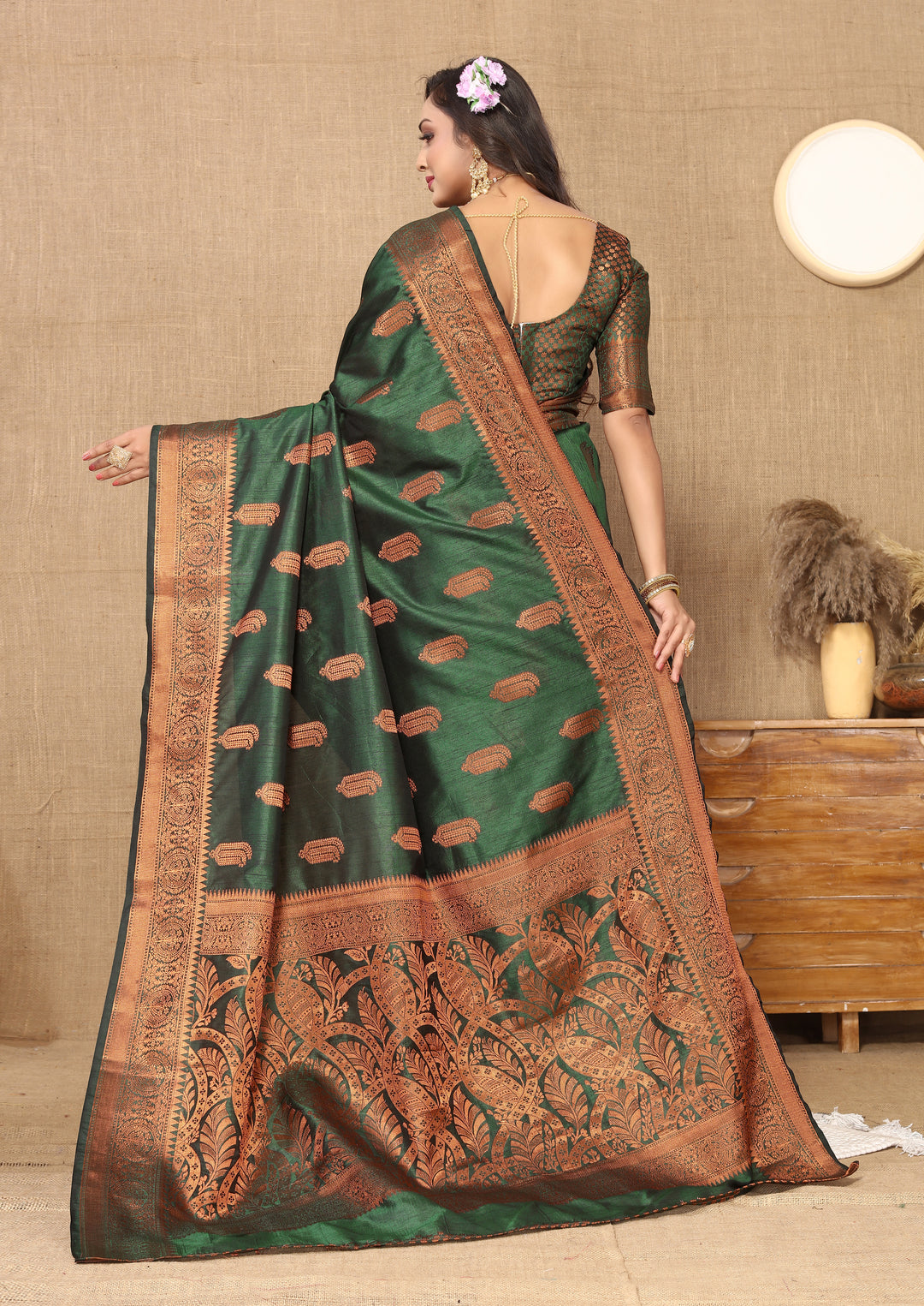 Luxurious dark-green Katan silk saree with intricate zari border, perfect for cultural celebrations.