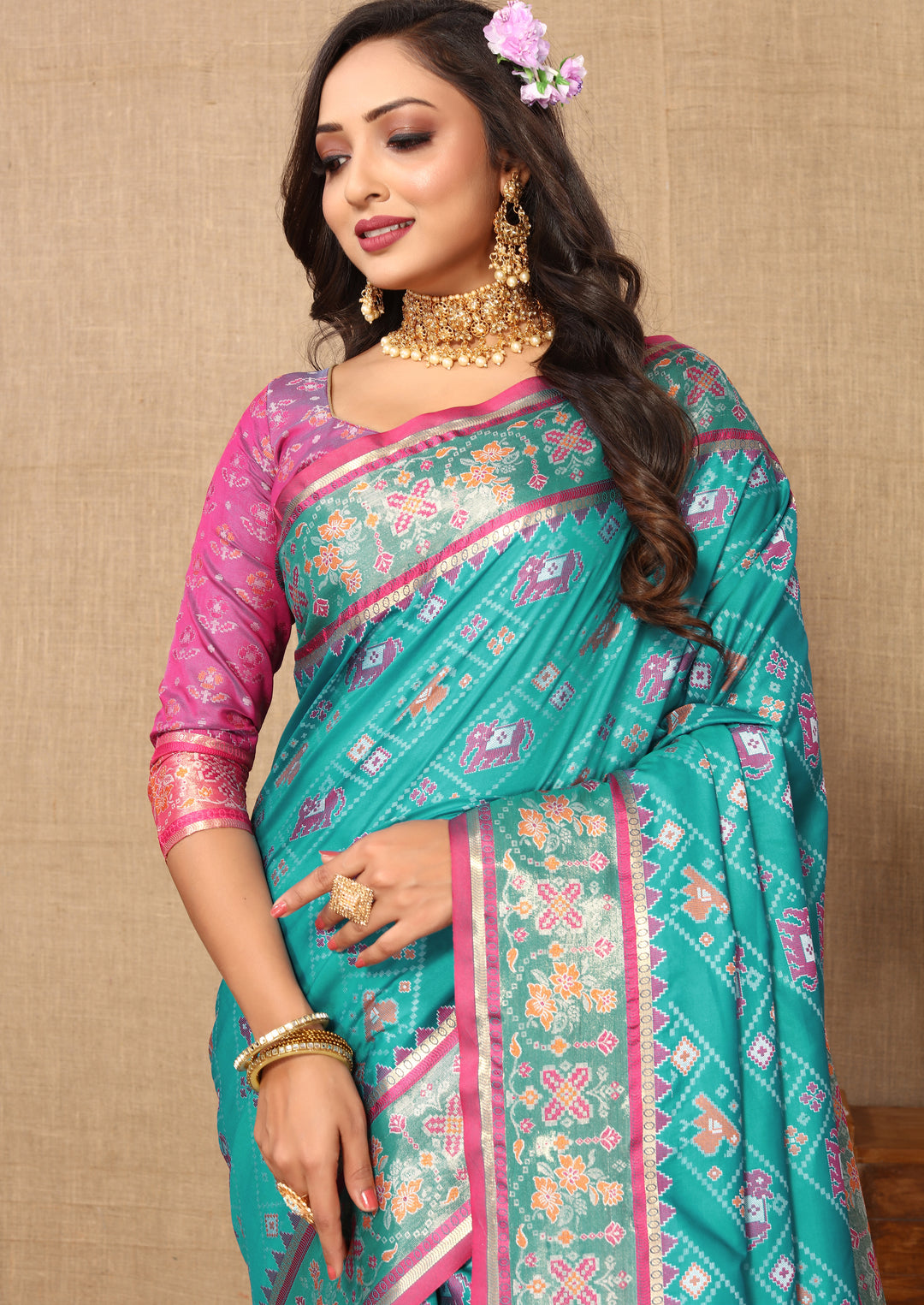 Beautiful turquoise Patola silk saree with Meenakari detailing and zari embellishments, perfect for weddings.