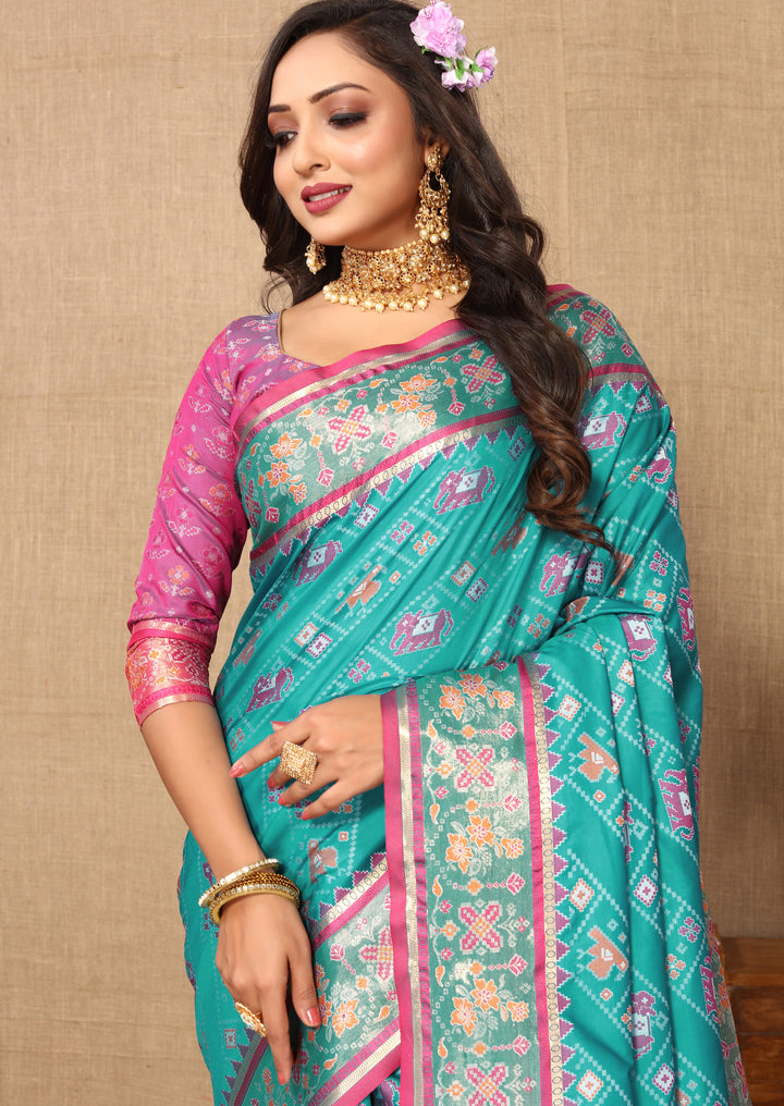 Beautiful turquoise Patola silk saree with Meenakari detailing and zari embellishments, perfect for weddings.