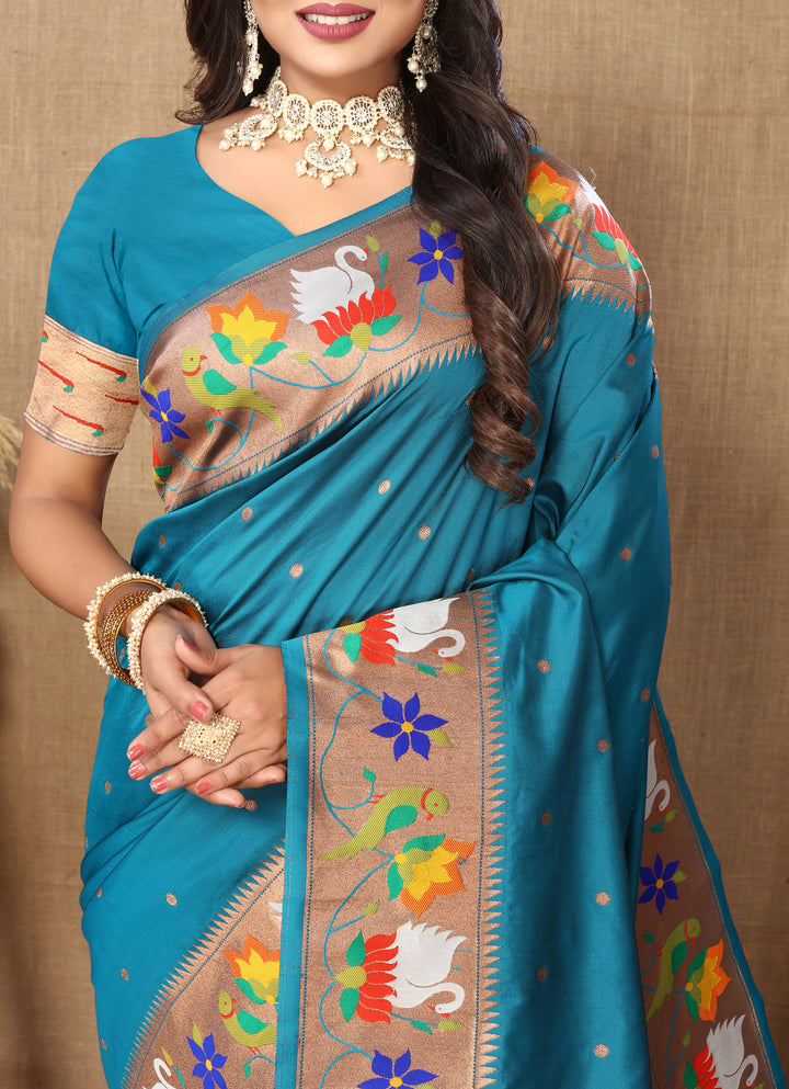 Beautiful sky-blue Paithani silk saree with rich meenakari weaving and a golden zari border, perfect for festive events.