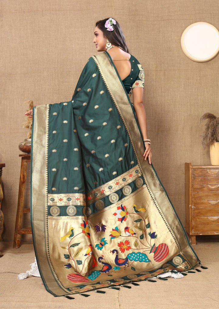 Teal green designer silk saree with matching blouse and intricate zari detailing, ideal for cultural gatherings.