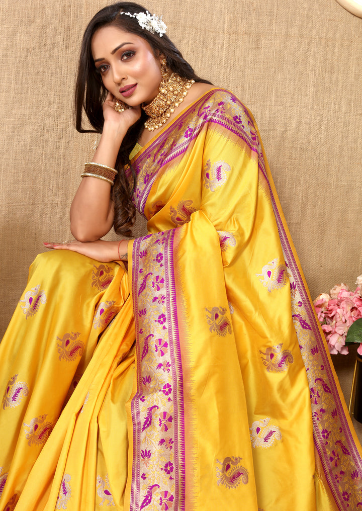 Yellow Paithani saree with intricate zari border and tassels, perfect for festive gatherings.