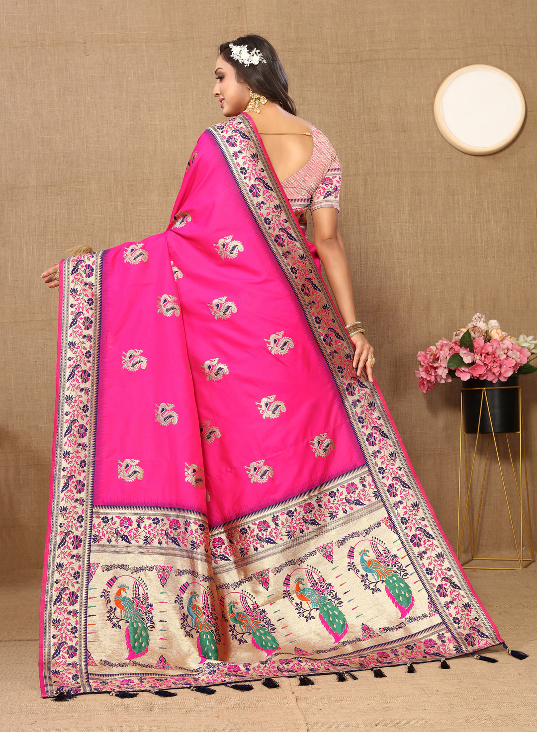 Sophisticated bright-pink silk saree with zari border and tassels, perfect for traditional gatherings.