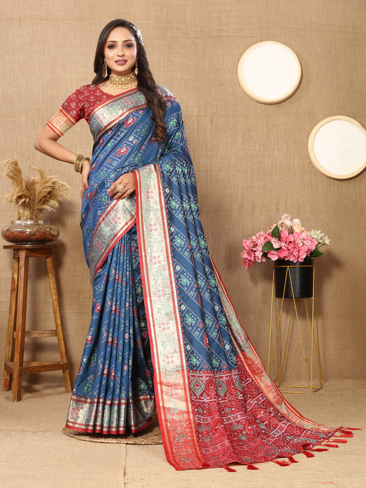 Elegant teal blue Patola silk saree with Meenakari motifs and zari detailing, perfect for weddings and cultural occasions.