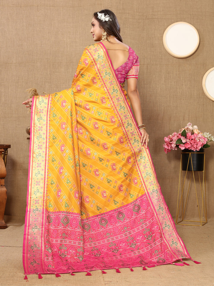 Elegant yellow Patola silk saree with rich Meenakari and zari work, complemented by a silk blouse piece for weddings.