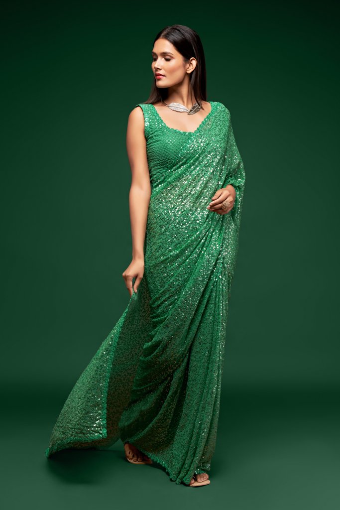 Elegant mint green Indian sari beautifully draped, featuring shimmering sequins detailing for a fresh and glamorous look at parties.