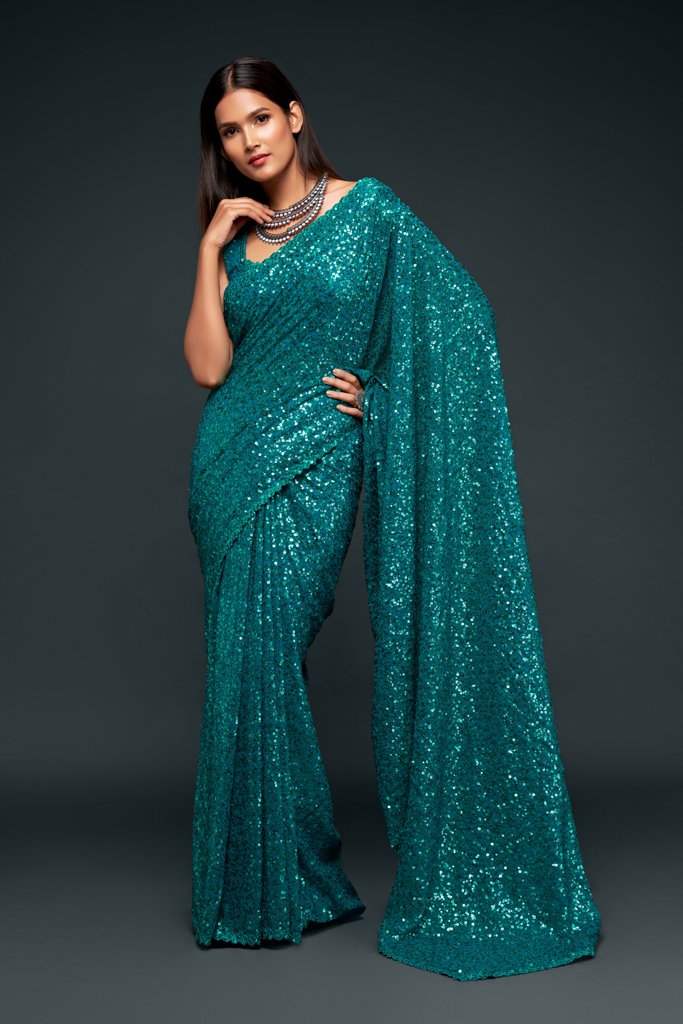 Gorgeous teal Indian sari draped elegantly, adorned with shimmering sequins, ideal for festive events and parties.