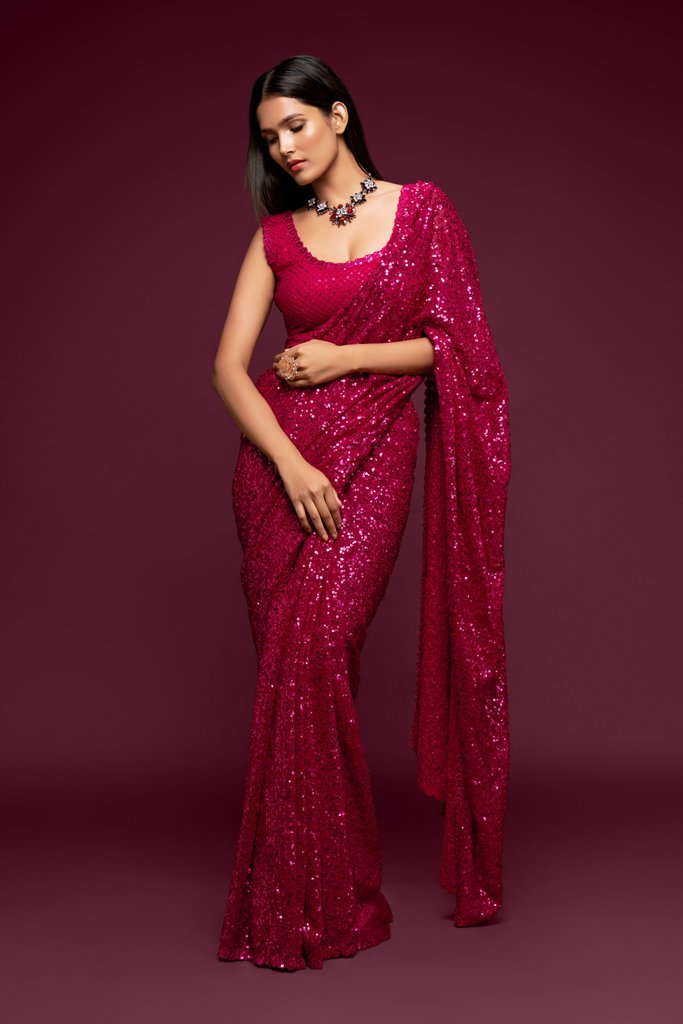 Hot pink Indian sari elegantly draped, featuring glamorous sequins detailing for an eye-catching look at parties and gatherings.