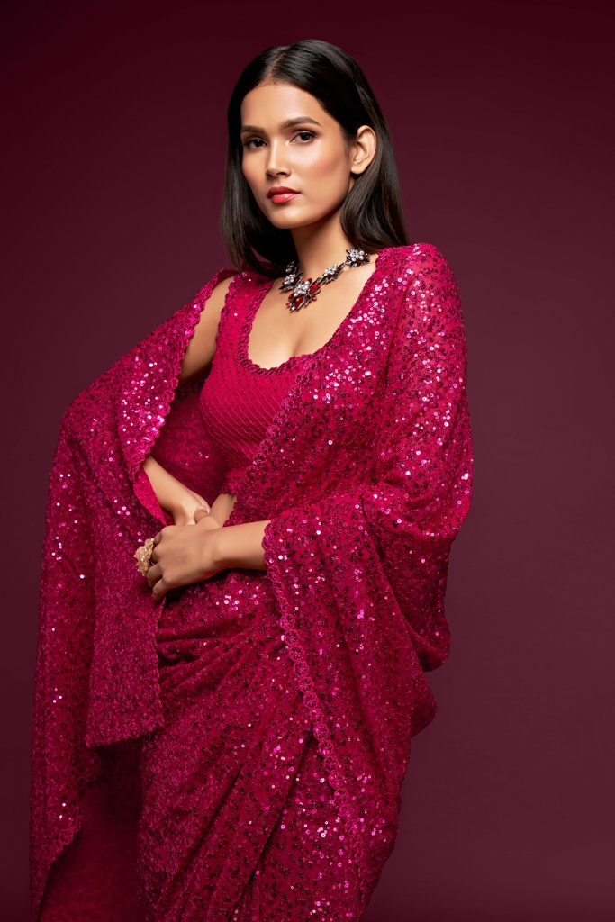 Vibrant hot pink Indian saree adorned with exquisite sequins, designed to make a statement at any event as a fancy saree.