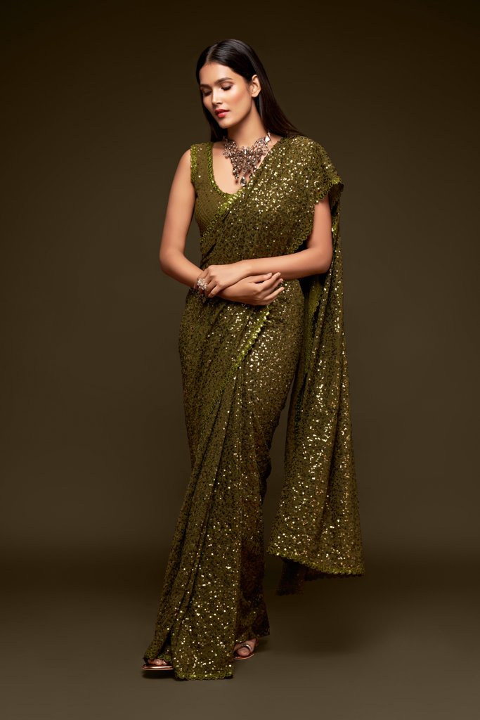 Elegant olive Indian sari beautifully draped, featuring shimmering sequins, ideal for festive events and celebrations.