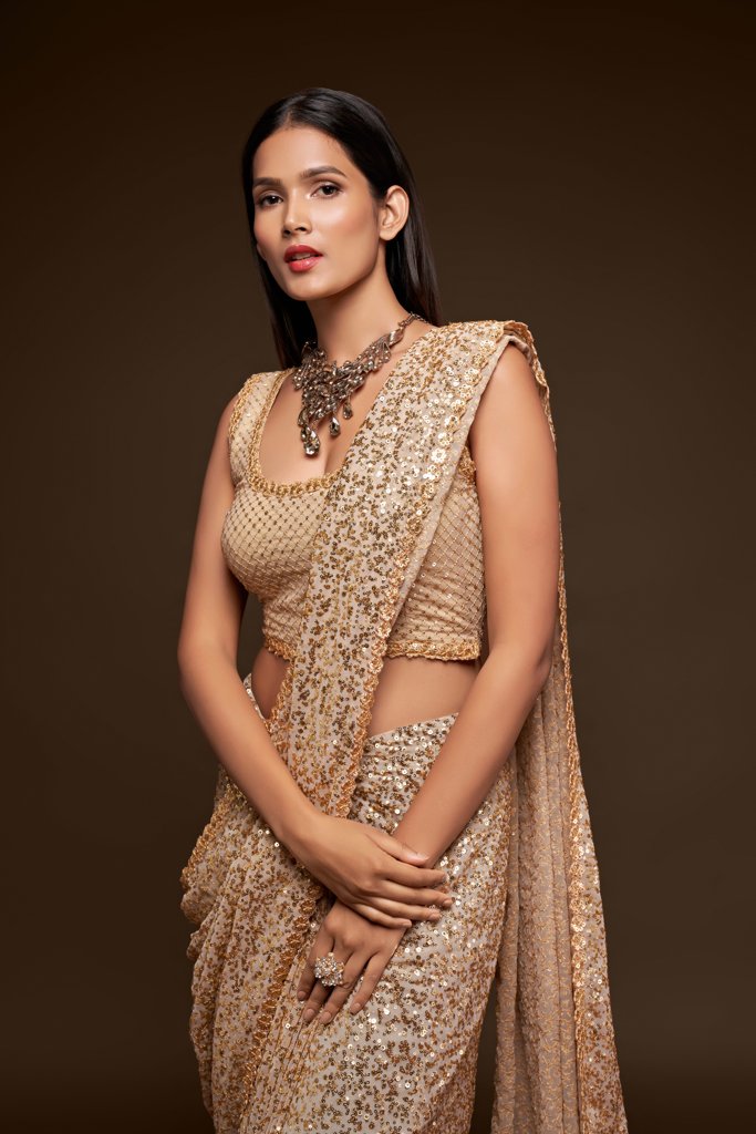 Elegant beige sadi showcasing intricate sequins embroidery, a versatile choice among fancy sarees for special occasions.