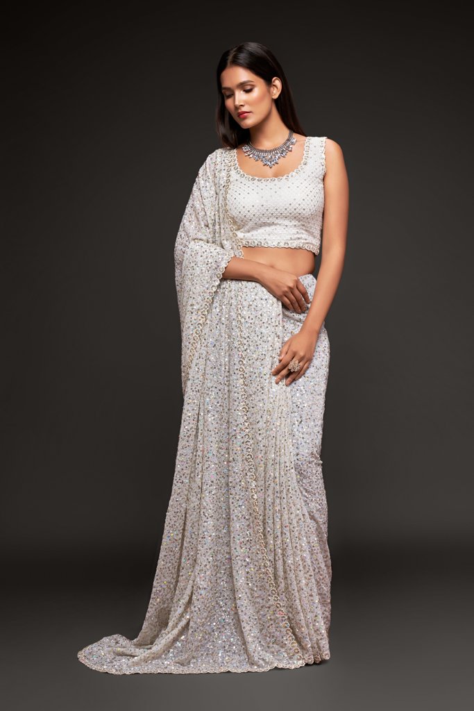 White saree elegantly draped, featuring beautiful sequins detailing for a glamorous look at parties and weddings.