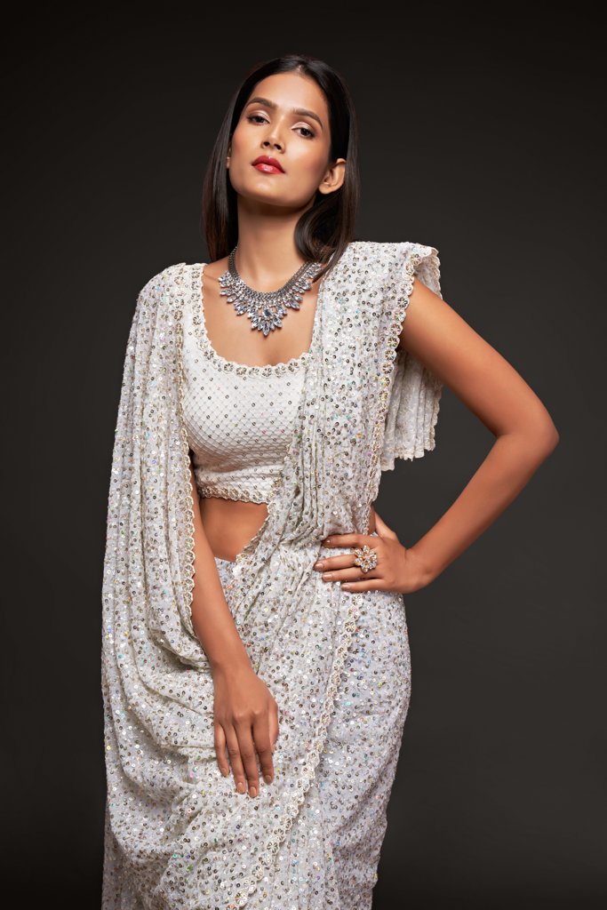 Timeless white saree showcasing intricate sequins work, a versatile choice for festive events and gatherings.