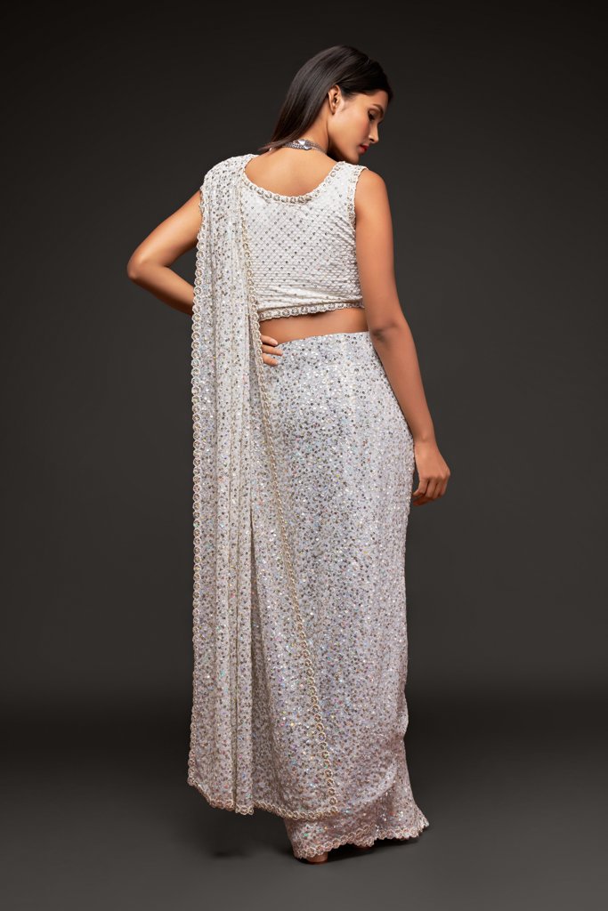 Elegant white saree featuring detailed sequins embroidery, complete with an unstitched blouse piece for a tailored fit.