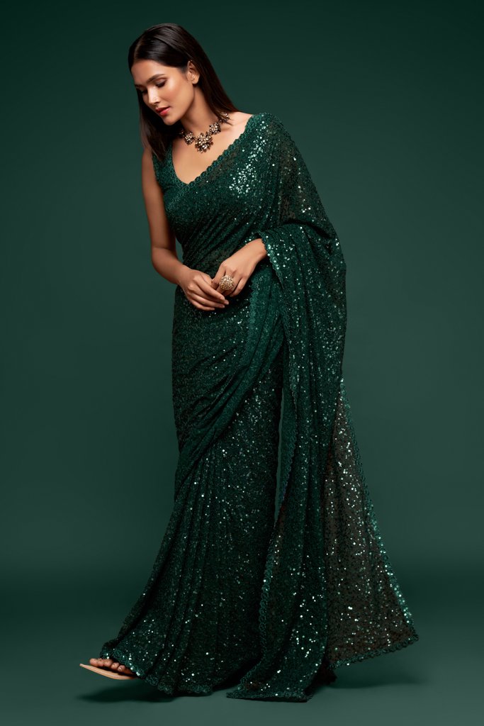 Dark green Indian sari elegantly draped, featuring glamorous sequins detailing for a standout look at weddings.