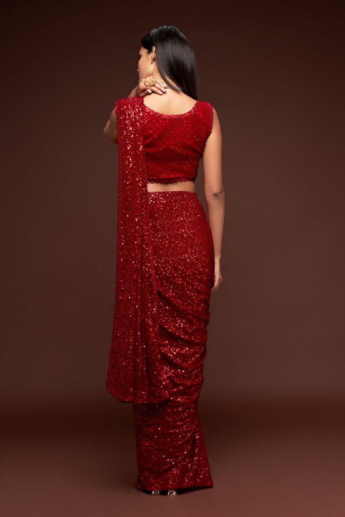 Vibrant ruby red Indian saree showcasing exquisite sequins work, designed to turn heads among fancy sarees at any event.