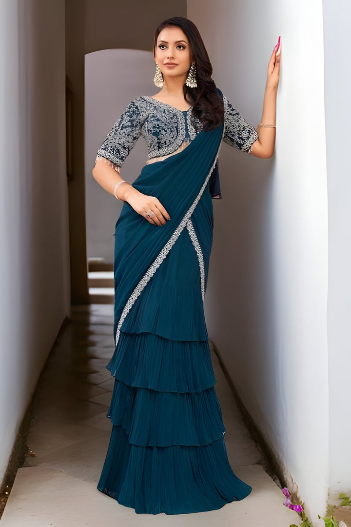 Designer blue georgette saree draped with hand-painted floral designs, perfect for elegant occasions.