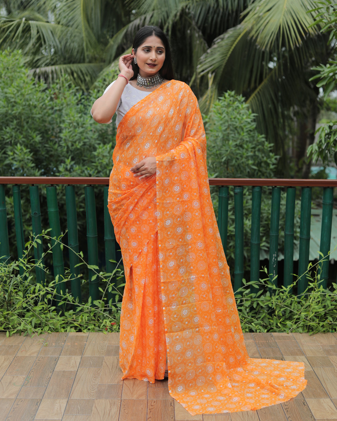 Elegant orange chiffon saree featuring foil detailing, offering a luxurious and chic look.