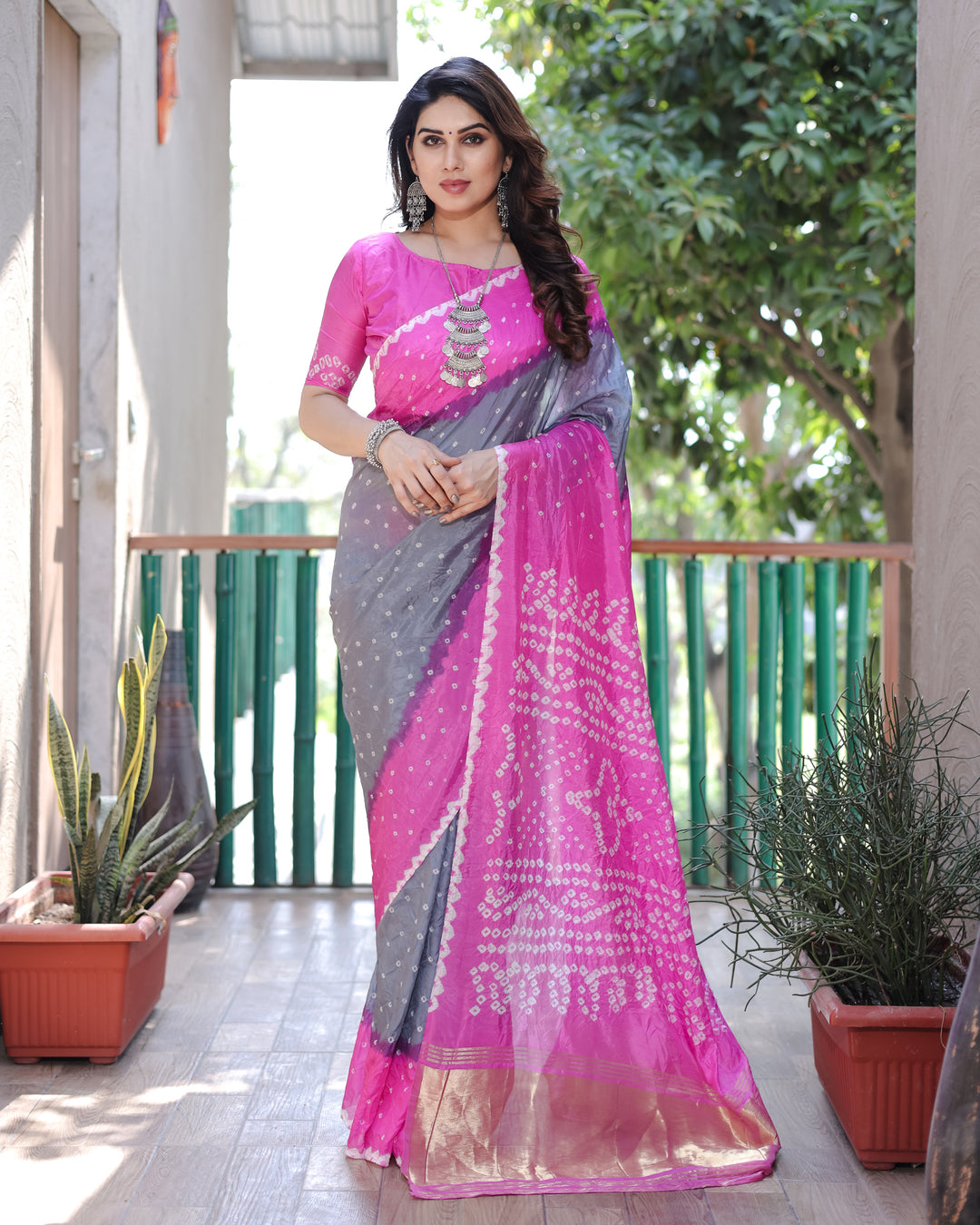 Add glamour with Hot-Pink Bandhej Silk Drapes with a Zari Tissue Pallu and elegant blouse piece.