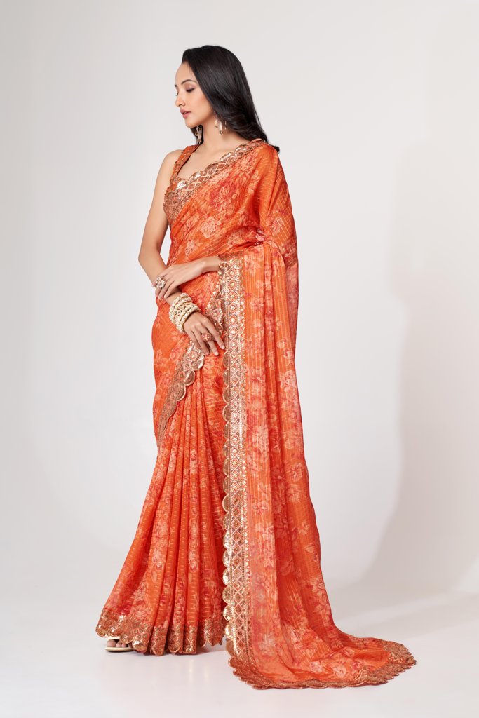 Vibrant orange floral print saree with sequin embroidery, perfect for celebratory events.