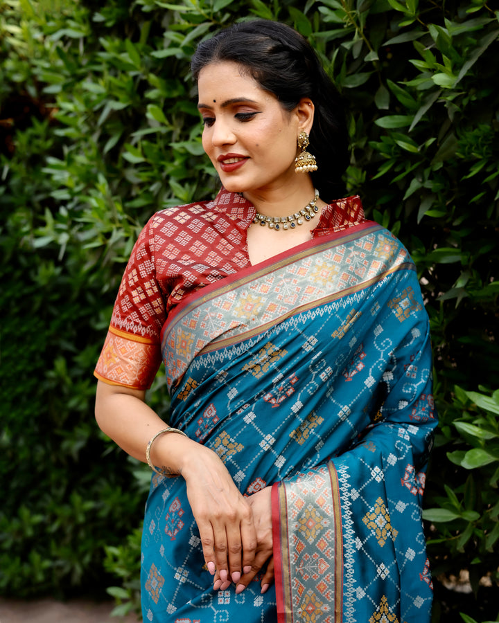 This teal Ikkat Patola silk saree combines exquisite Ikkat patterns and contrast Zari borders for a timeless, elegant look.