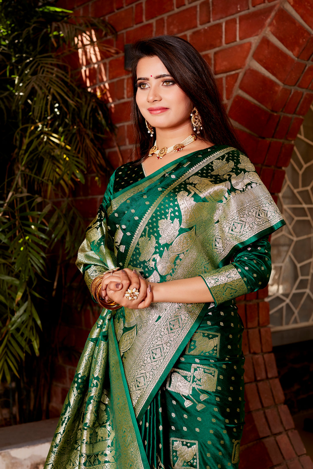 Beautiful dark green Kanjivaram satin silk saree with intricate butta work and a matching woven pallu, perfect for traditional celebrations.