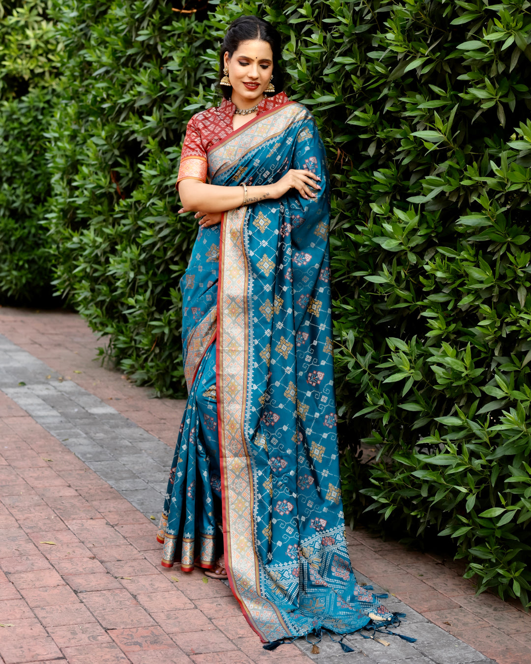 Make a statement with this teal Ikkat Patola silk saree featuring contrast Zari borders and a stunning, intricately designed pallu.