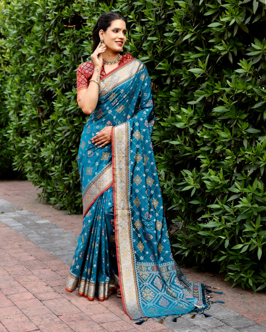 Graceful and elegant, this teal Ikkat Patola silk saree with intricate Zari borders is the ideal choice for festive occasions.