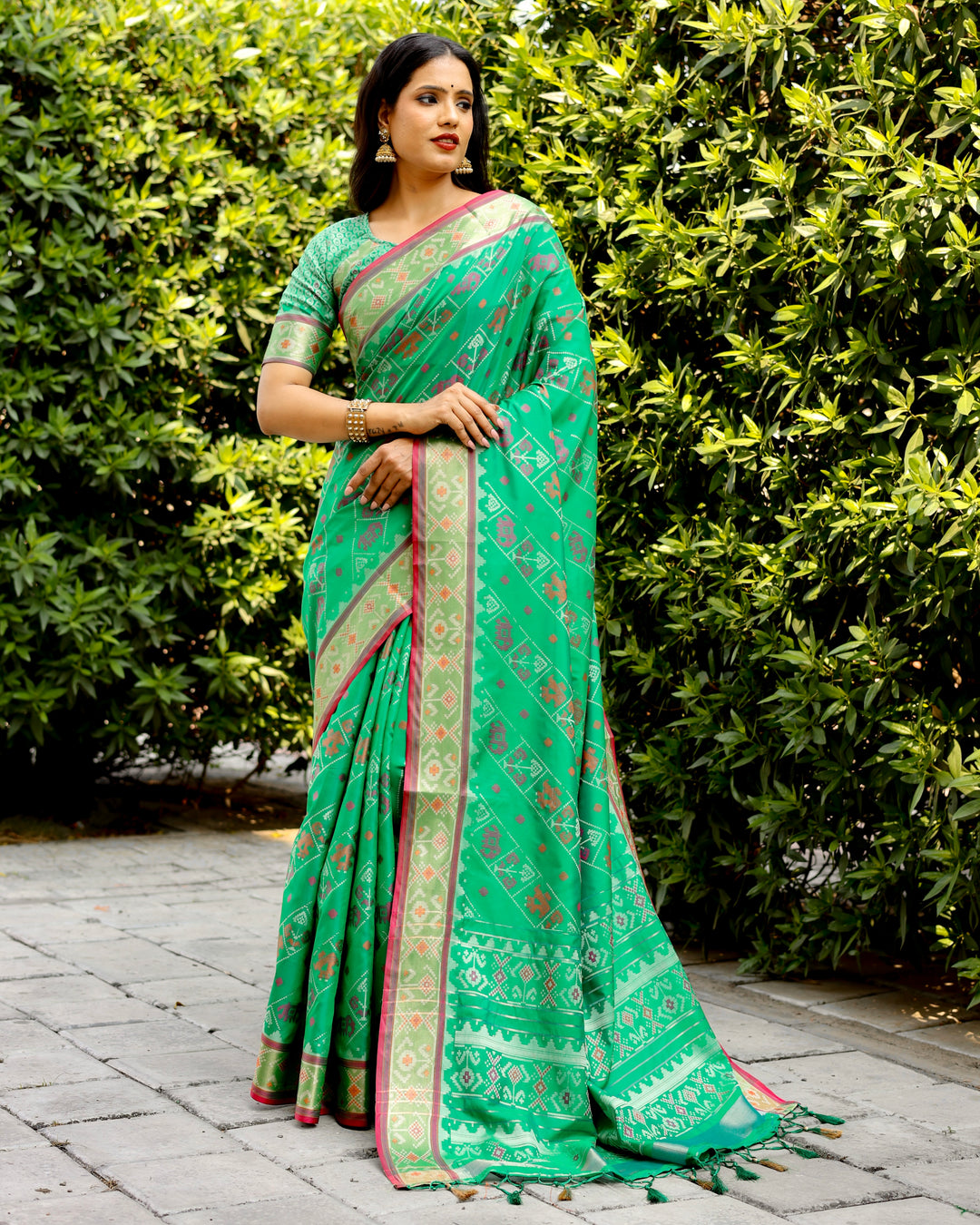 Elegant green Bandhej silk saree with matching blouse and intricate zari woven pallu, ideal for celebrations.