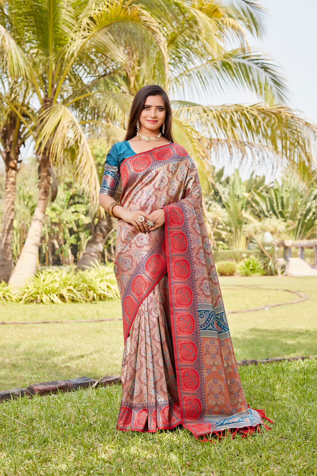 Designer coral-pink Kanjivaram silk saree with rich pallu and delicate work, perfect for celebrations.