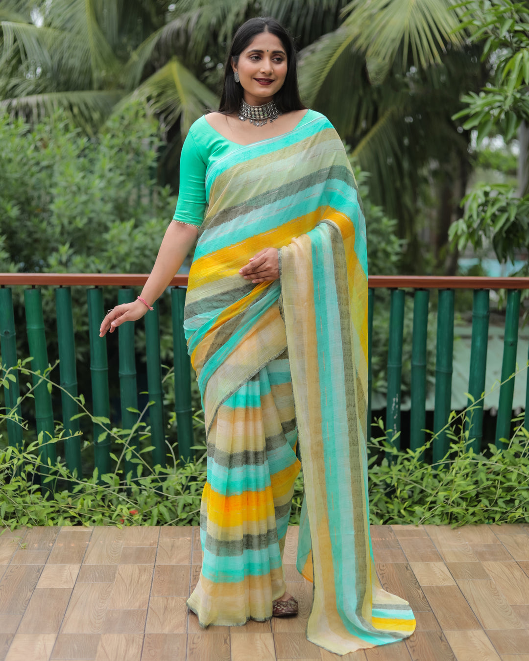 Add a touch of sophistication with this deep mint Moss chiffon saree, adorned with delicate gold foil detailing for a festive look.