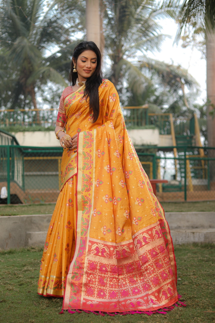 Stylish yellow organza saree featuring Ikkat Patola print, ideal for festive and casual events.