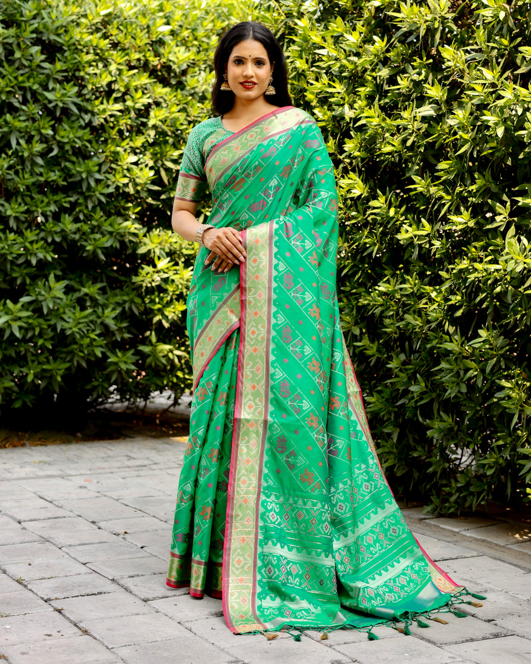 Rich green Bandhej silk saree with zari woven pallu and matching blouse, perfect for grand and luxurious wear.