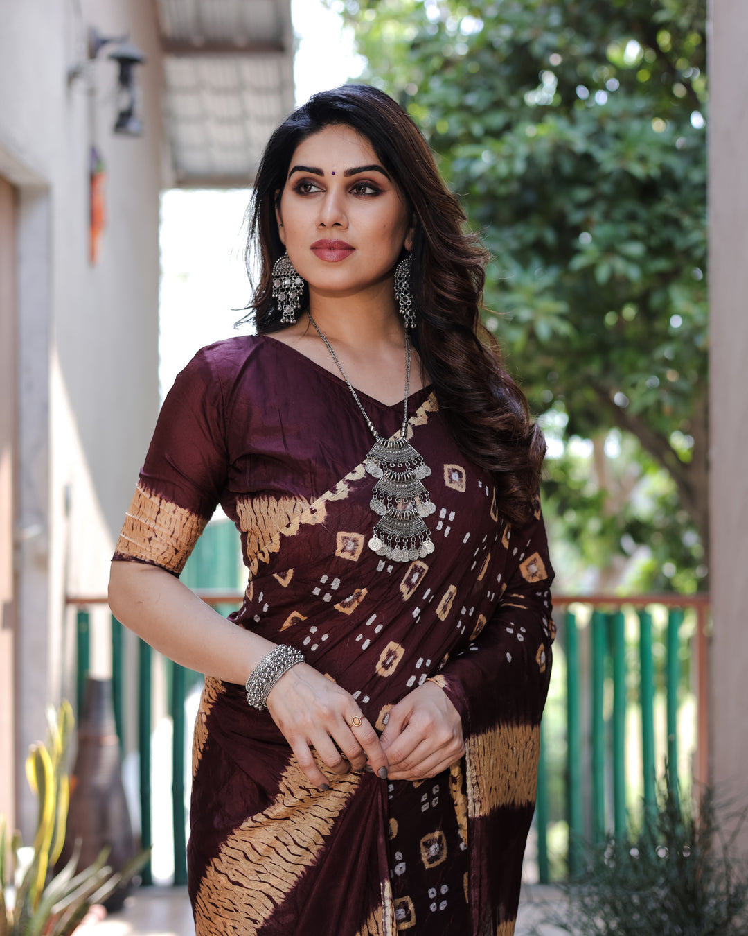 Rich wine-colored Bandhej silk saree featuring exquisite traditional weaving and elegant Sibory motifs, perfect for celebrations.