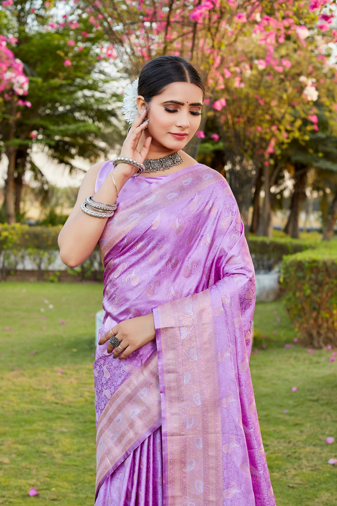 Soft lavender Kanjivaram satin silk saree featuring intricate butta designs and a woven pallu, perfect for festive wear.