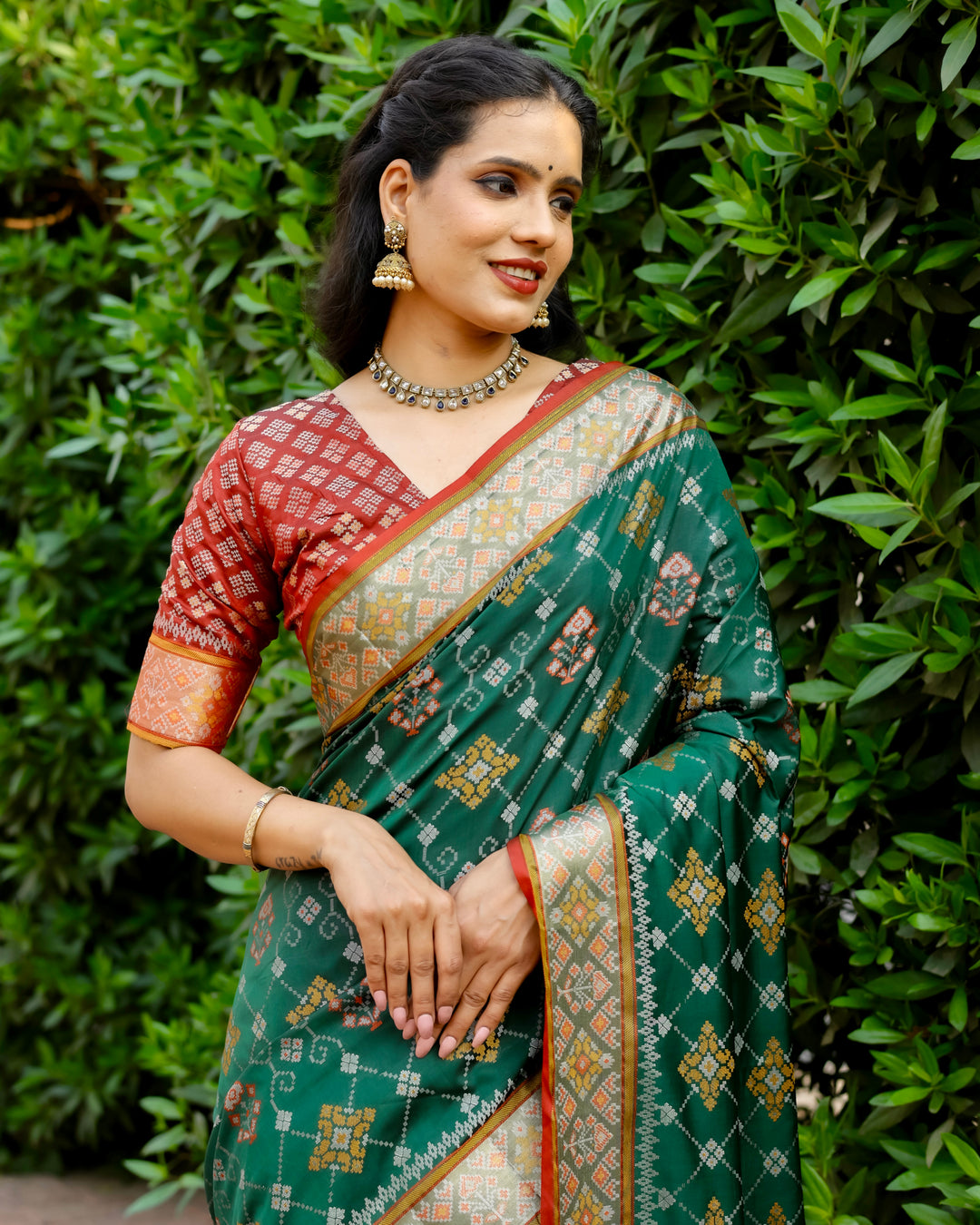 Add a sophisticated touch to your wardrobe with this green Ikkat Patola silk saree, adorned with intricate Zari borders and Kanchi-style detailing.