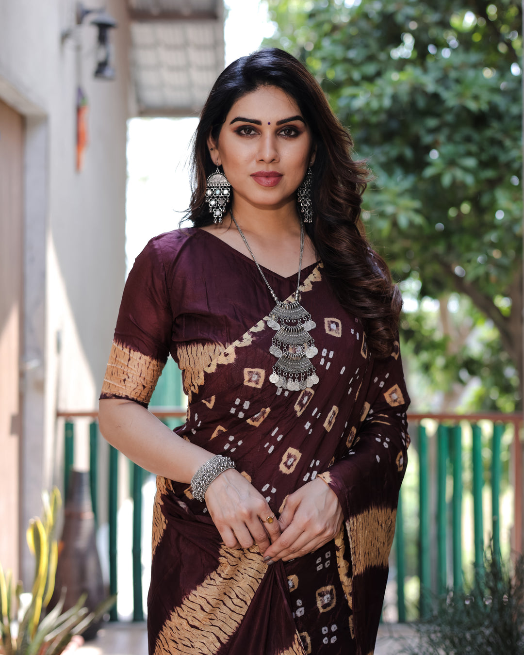 The wine Bandhej silk saree offers elegance with its intricate design and rich tissue pallu, ideal for festive occasions.