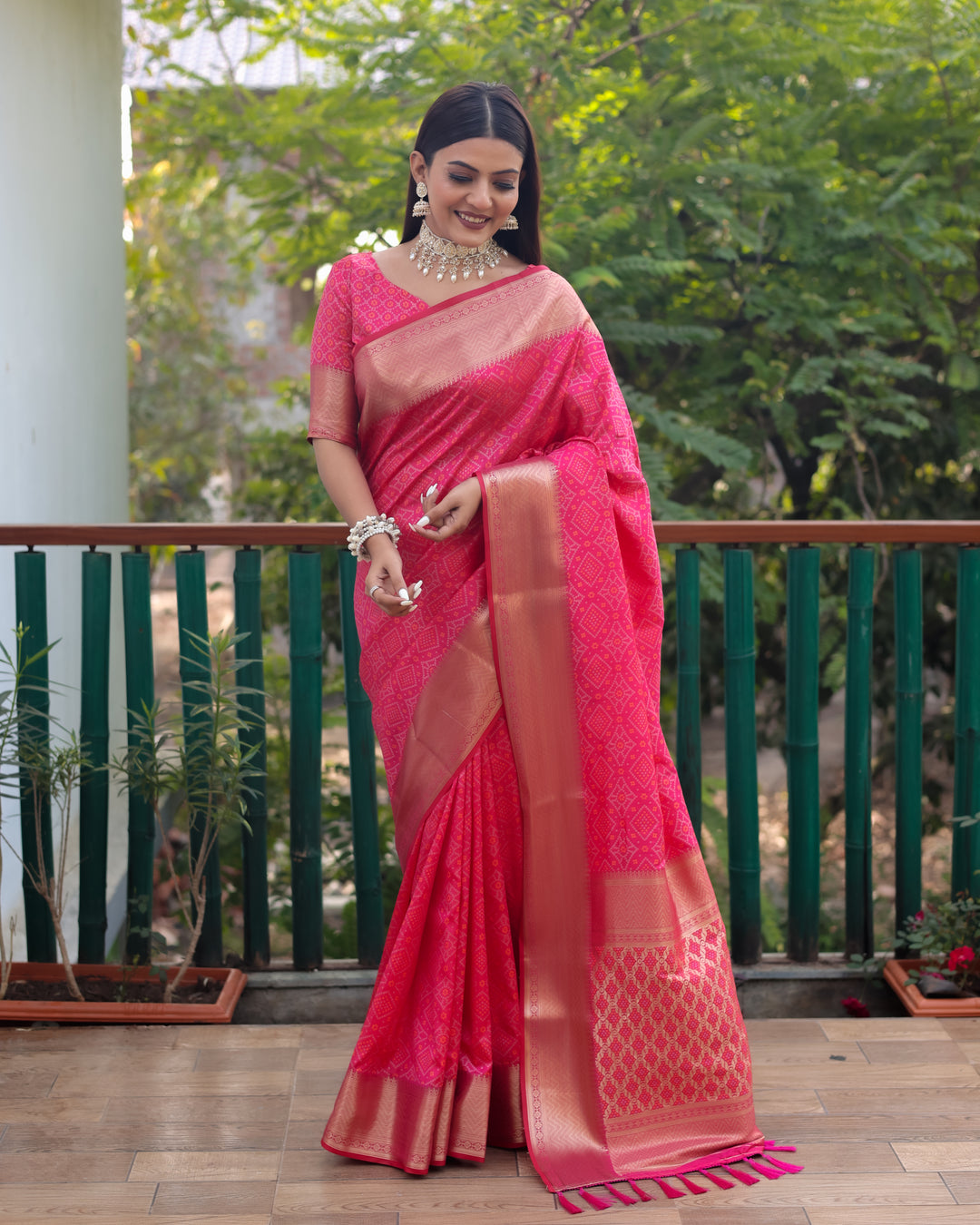 Exquisite bright pink Patola silk saree showcasing beautiful Bandhej patterns and contrast zari borders, embodying sophistication.