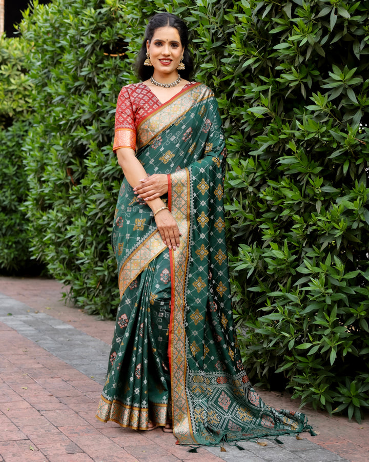 A luxurious green Ikkat Patola silk saree with beautiful contrast Zari borders and an intricately designed pallu for a festive look.