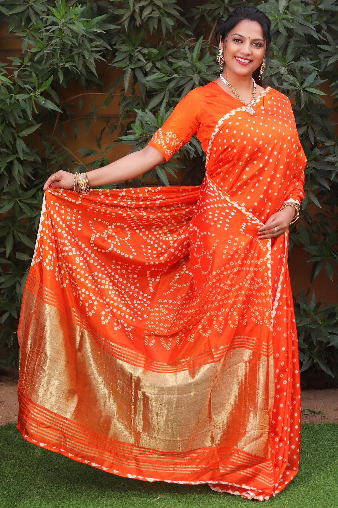 Vibrant orange Bandhej silk saree with Lagdi Patta and Zari Weaving pallu, a festive must-have for Indian occasions.