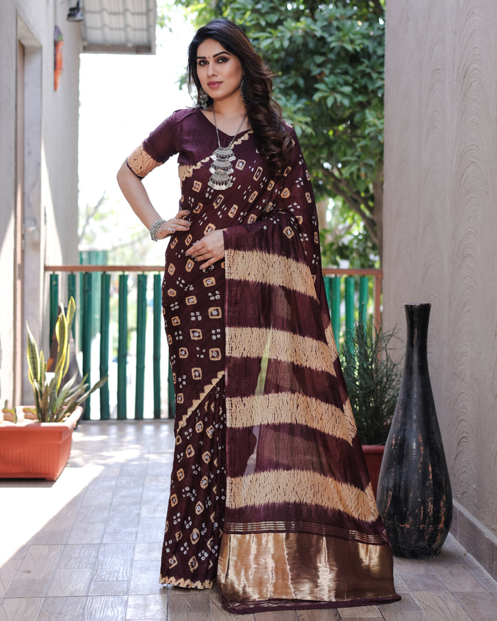 Timeless wine Bandhej silk saree with an elegant tissue pallu, Zari weaving, and stunning Sibory motifs.