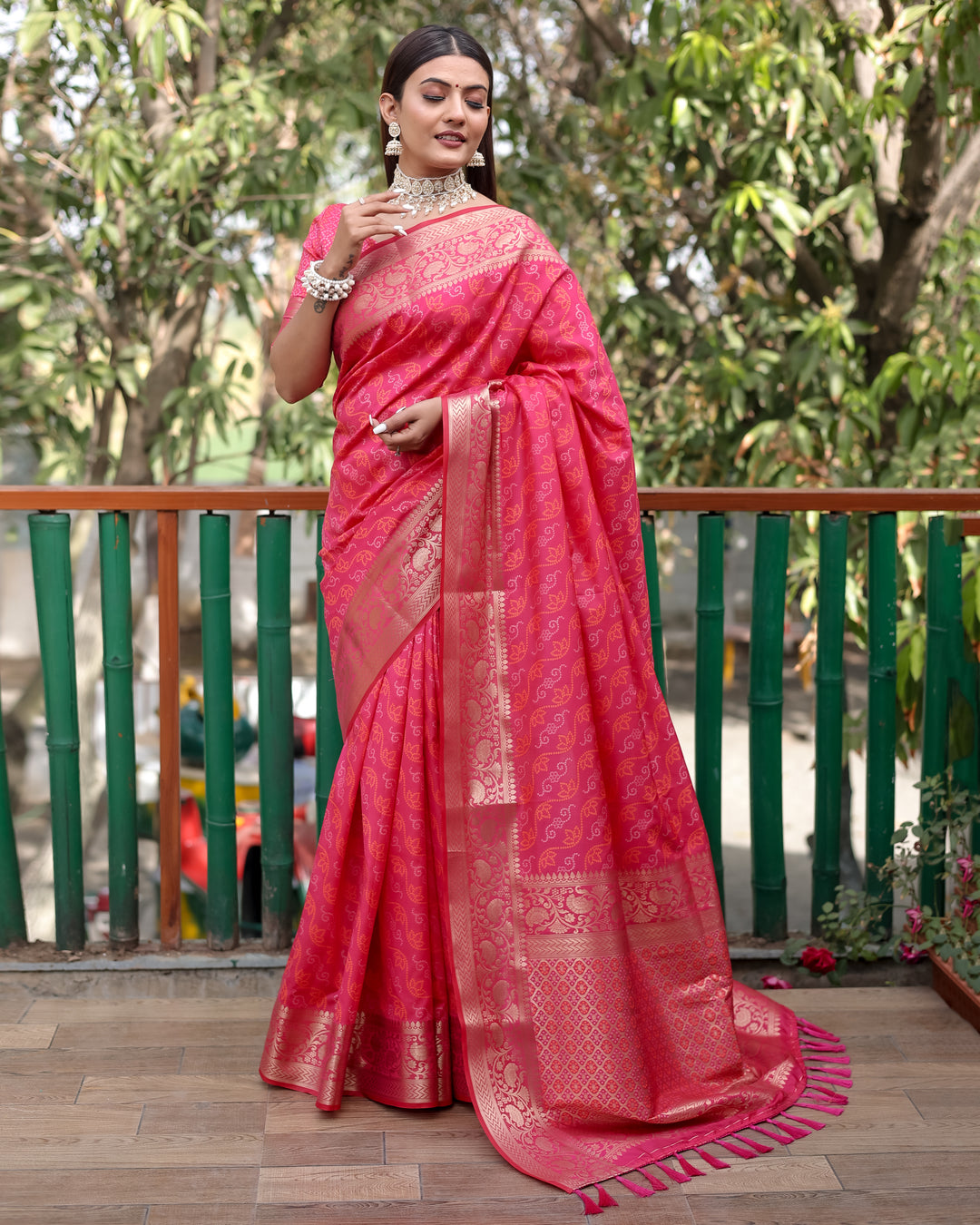 Elegant bright-pink Bandhej Patola saree with intricate zari work and regal Kanchi borders, perfect for celebrations.