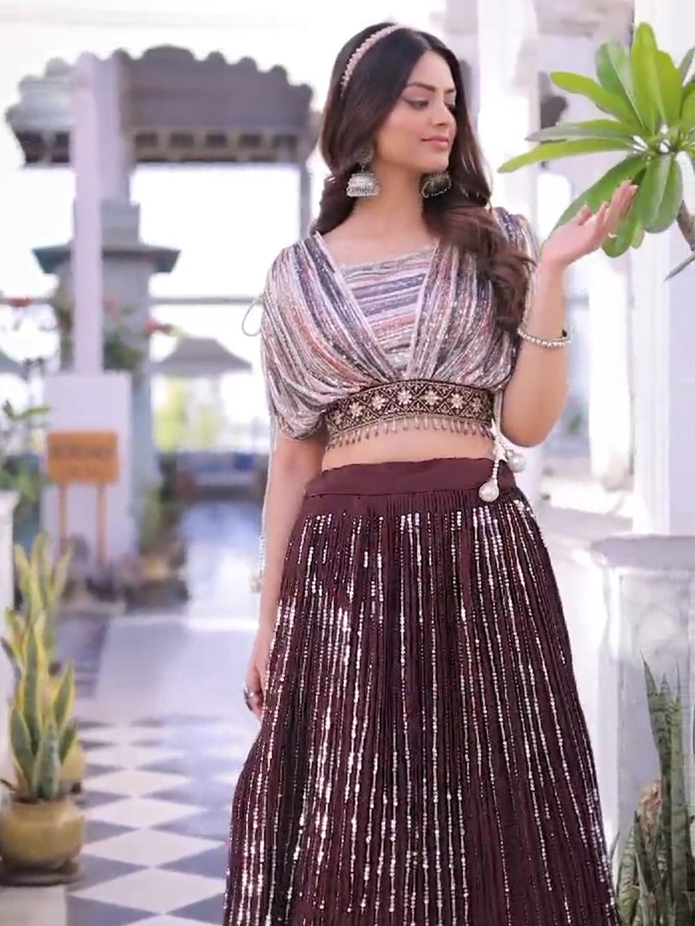 Elegant brown lehenga set featuring a floral crop top, perfect for festive occasions.