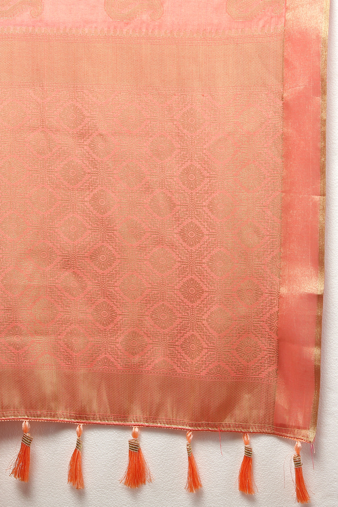 Traditional peach cotton saree with zari detailing and tassels at the pallu, ideal for festive gatherings.