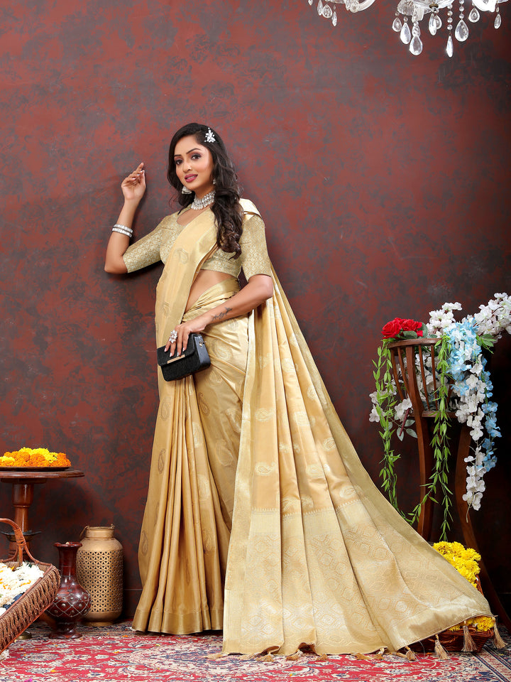 Graceful beige cotton saree with intricate zari detailing and tassels at the pallu, ideal for cultural celebrations.