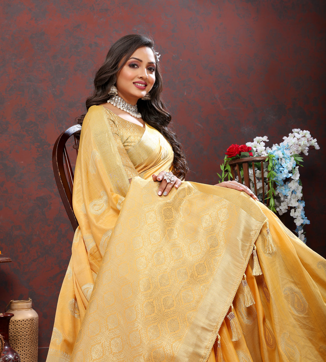 Soft yellow cotton saree with delicate zari weaving and tassels at the pallu, perfect for special events.